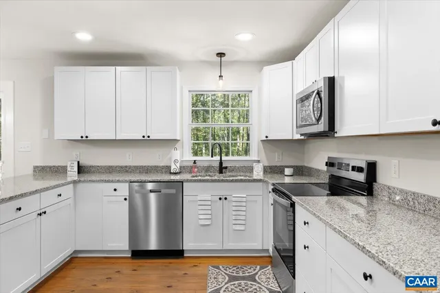 a kitchen with stainless steel appliances granite countertop a sink stove and cabinets