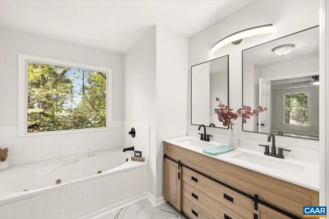a bathroom with a tub sink and mirror