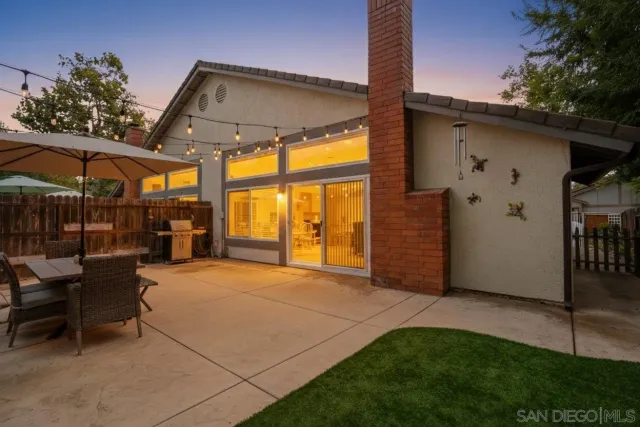 a view of a patio with a table and chairs under an umbrella