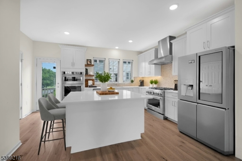 32 Gala Court Livingston, NJ 07039 - Photo 3 of 17 a kitchen with stainless steel appliances a refrigerator a stove a sink dishwasher and a dining table with wooden floor