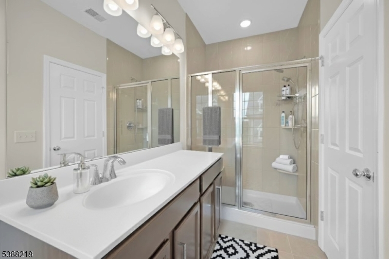 32 Gala Court Livingston, NJ 07039 - Photo 10 of 17 a bathroom with a granite countertop sink a shower and a mirror