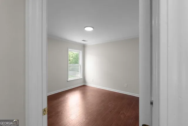 a view of room with window and wooden floor
