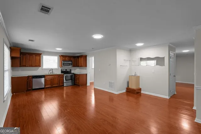 a view of kitchen with refrigerator and wooden floor