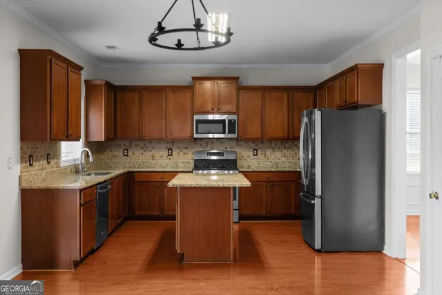 a kitchen with stainless steel appliances granite countertop a refrigerator a stove top oven a sink and dishwasher