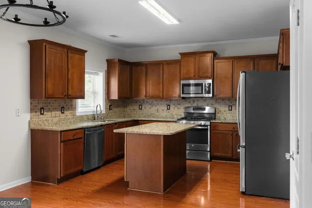 a kitchen with stainless steel appliances granite countertop a refrigerator stove and a sink