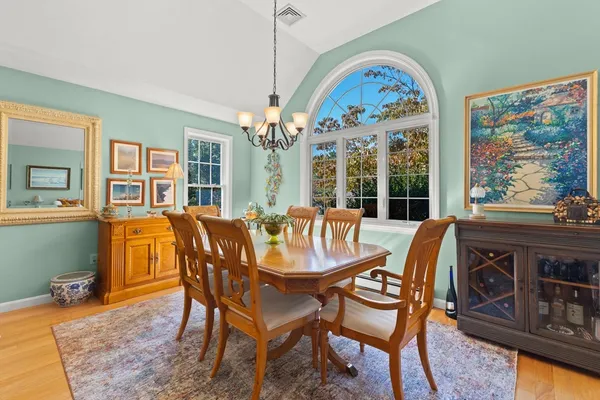 a dining room with furniture a chandelier and wooden floor