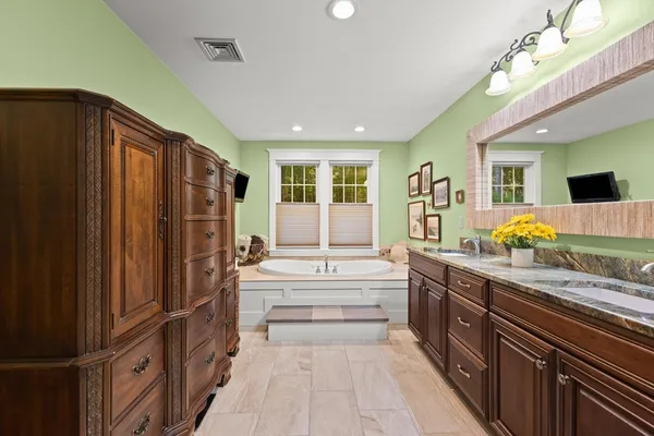 a bathroom with a tub sink and mirror