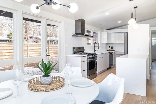 a kitchen with stainless steel appliances kitchen island granite countertop a stove a sink a dining table and chairs