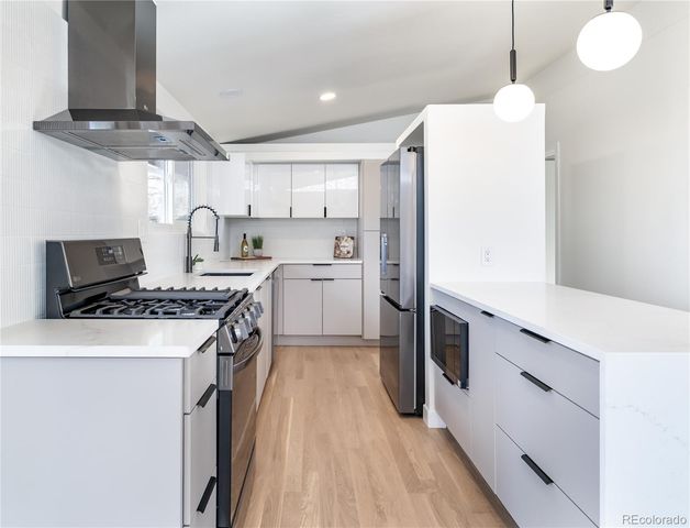 a kitchen with a stove a sink and a refrigerator