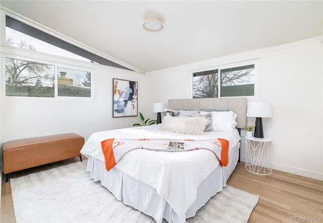 a bedroom with bed and wall painting with wooden floor