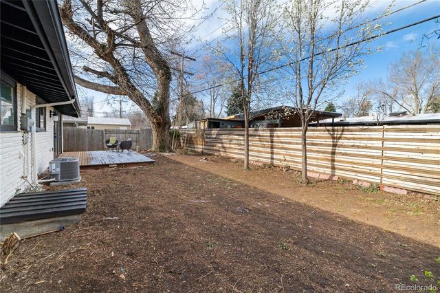 a view of a yard with wooden fence