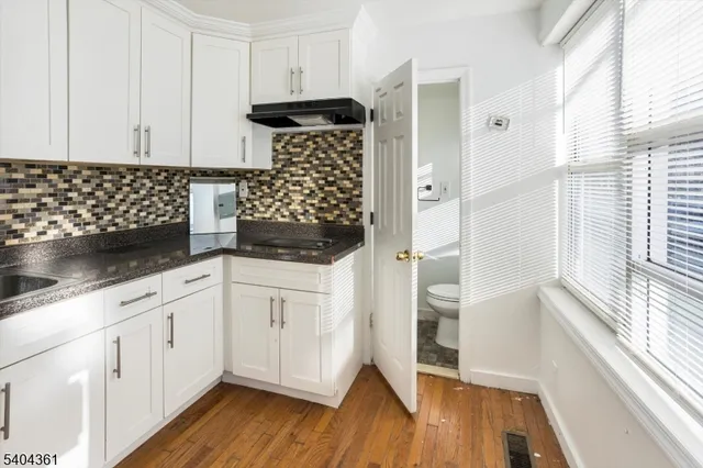 a kitchen with stainless steel appliances a refrigerator and wooden floor