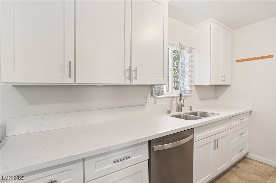 4027 Maple Hill Road Las Vegas, NV 89115 - Photo 13 of 46 Kitchen featuring stainless steel dishwasher, white cabinets, and light stone counters