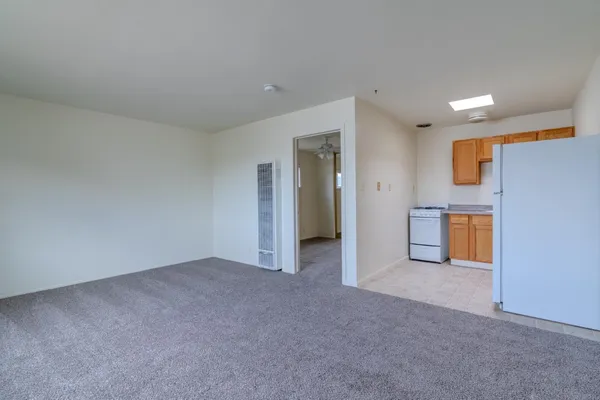 a view of an empty room with a kitchen