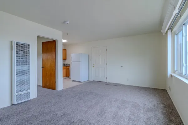 an empty room with closet and a window