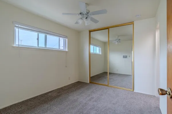 an empty room with windows and closet