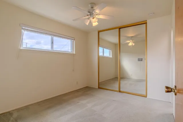 an empty room with fan and windows