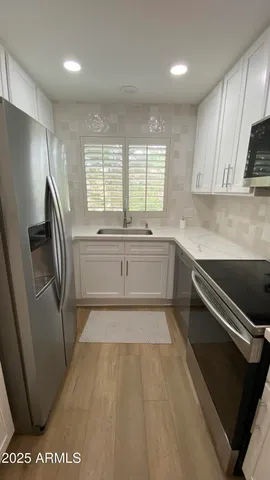 a large kitchen with a sink and stainless steel appliances
