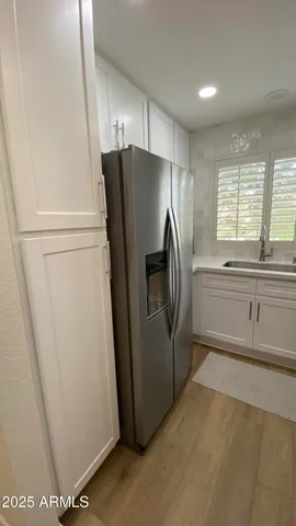 a view of a kitchen with refrigerator and window