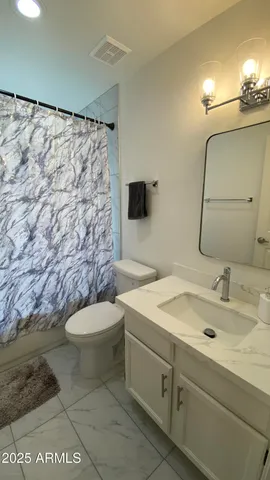 a bathroom with a sink a toilet and a mirror