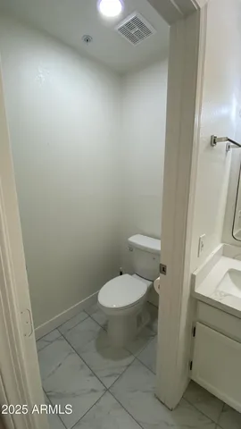 a white toilet sitting next to a sink and vanity