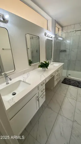 a bathroom with a double vanity sink mirror and shower