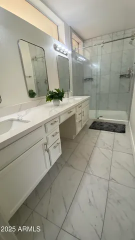 a bathroom with a double vanity sink mirror and bathtub