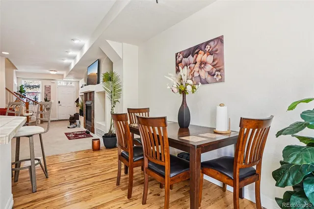 a kitchen with stainless steel appliances granite countertop a sink a stove a refrigerator cabinets and a dining table