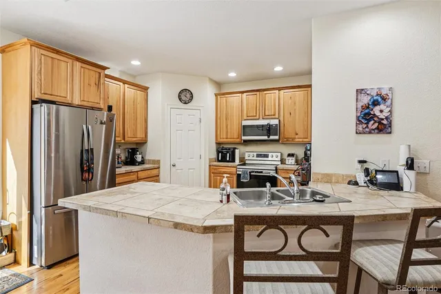 a kitchen with stainless steel appliances a stove top oven a sink and a refrigerator