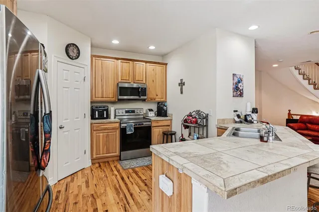 a kitchen with stainless steel appliances granite countertop a refrigerator stove and sink
