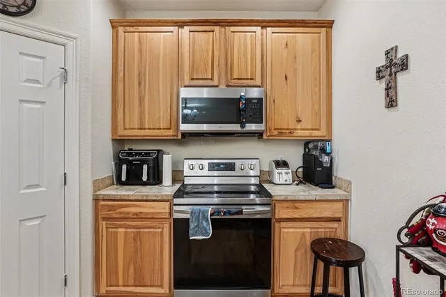 a kitchen with stainless steel appliances granite countertop a refrigerator a sink dishwasher and white cabinets with wooden floor