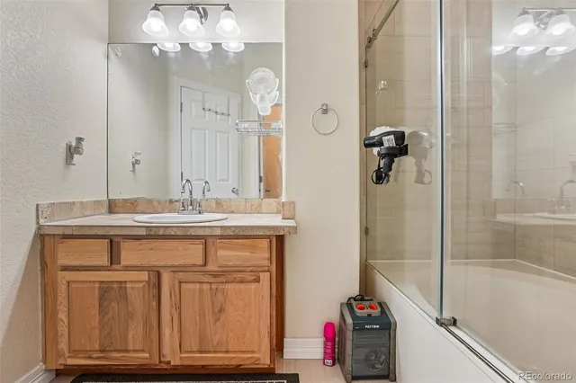 a bathroom with a tub sink and mirror