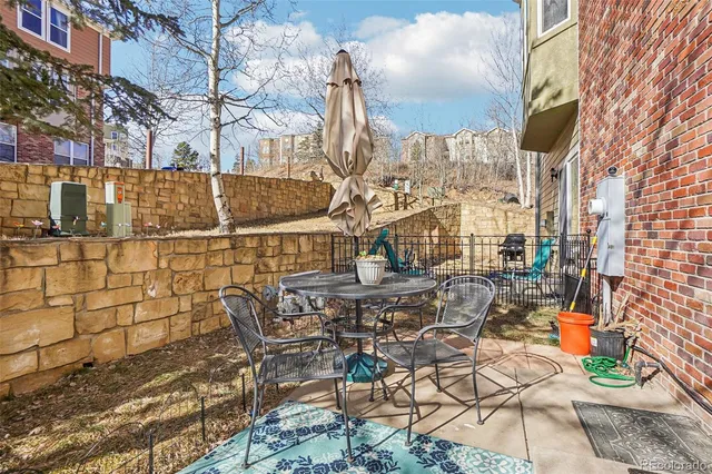 a backyard of a building with table and chairs