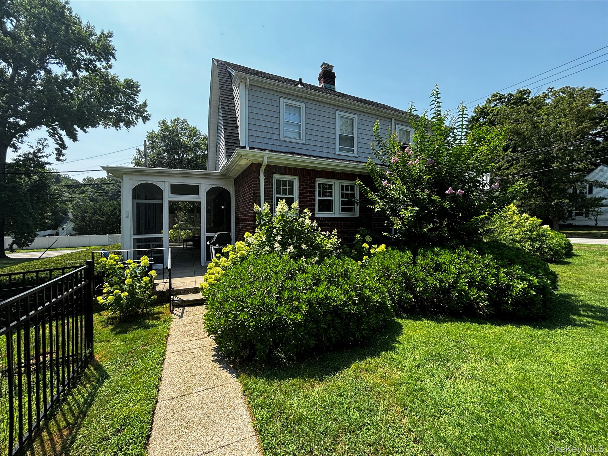 160 West Neck Road Huntington, NY 11743 - Photo 1 of 7 Rear view of house featuring a chimney, brick siding, a sunroom, a yard, and fence