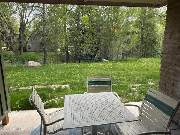 a view of a patio with table and chairs with wooden floor and fence