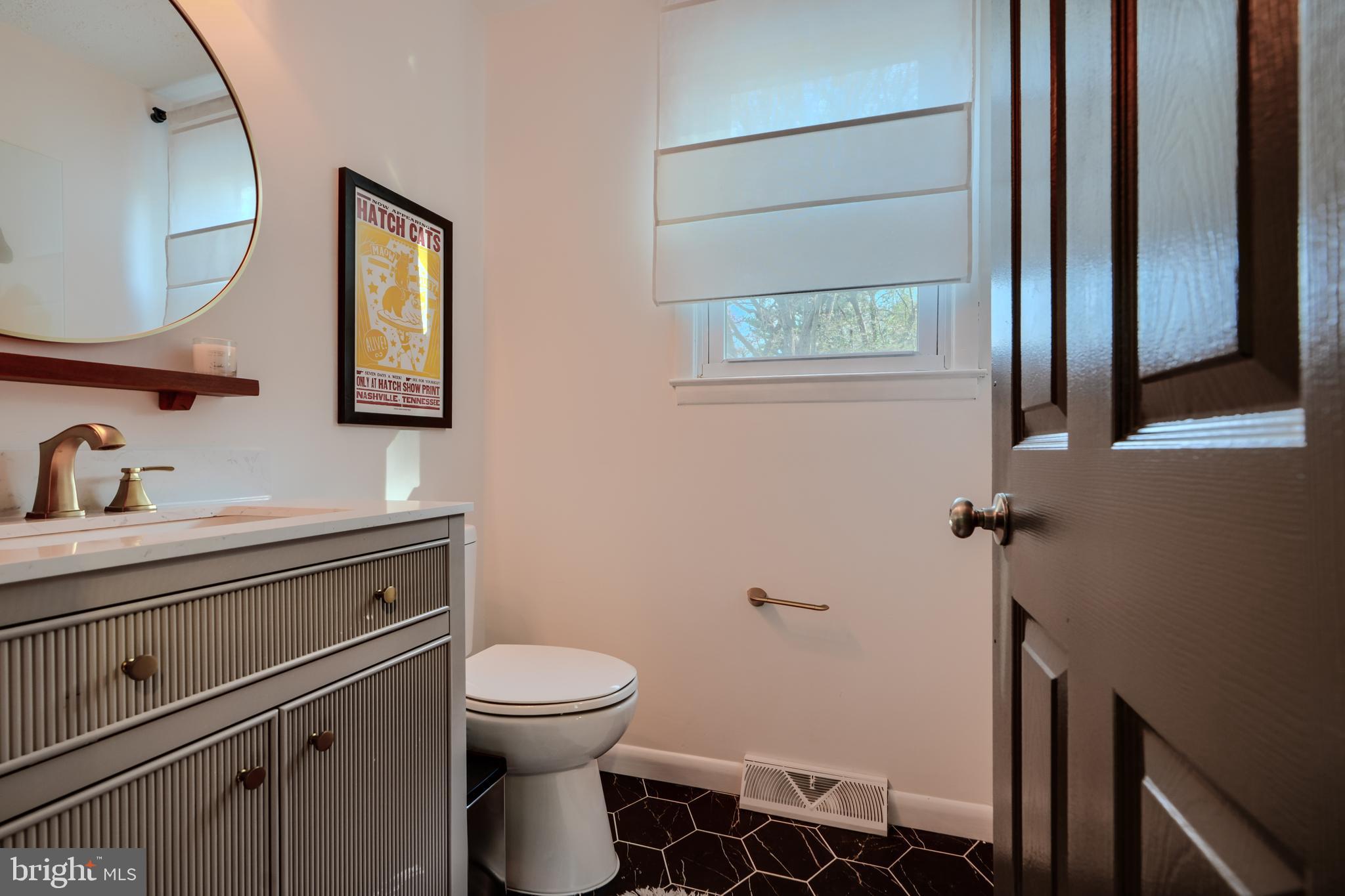 1103 Litchfield Road, Unit H Baltimore, MD 21239 - Photo 37 of 74 a bathroom with a toilet a sink and mirror