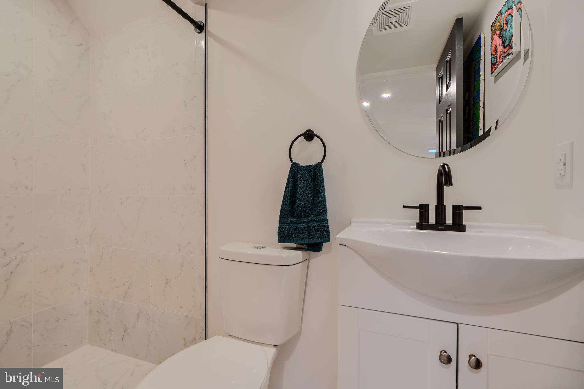 1103 Litchfield Road, Unit H Baltimore, MD 21239 - Photo 67 of 74 a bathroom with a toilet a sink and mirror