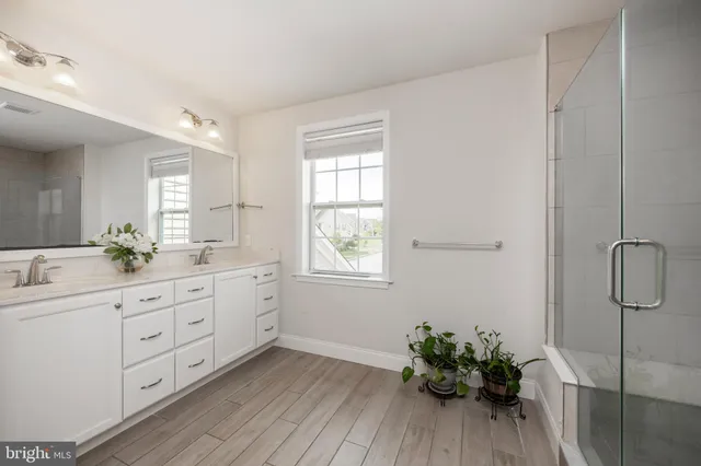 a spacious bathroom with a double vanity sink and a mirror