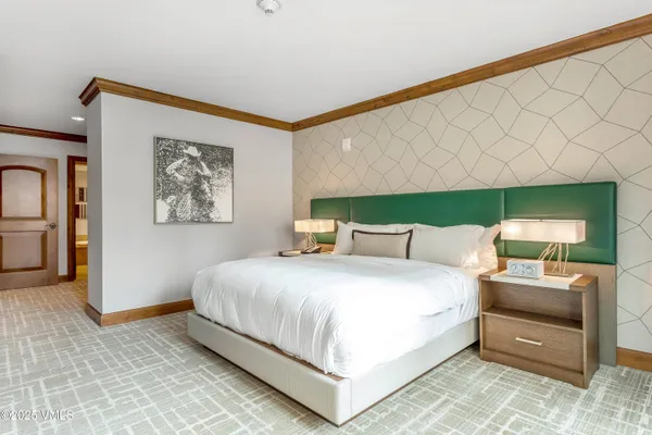 a bedroom with a large bed and a chandelier
