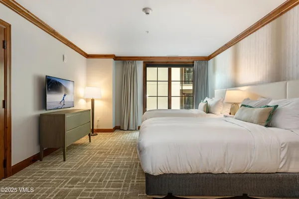 a bedroom with a bed and a television