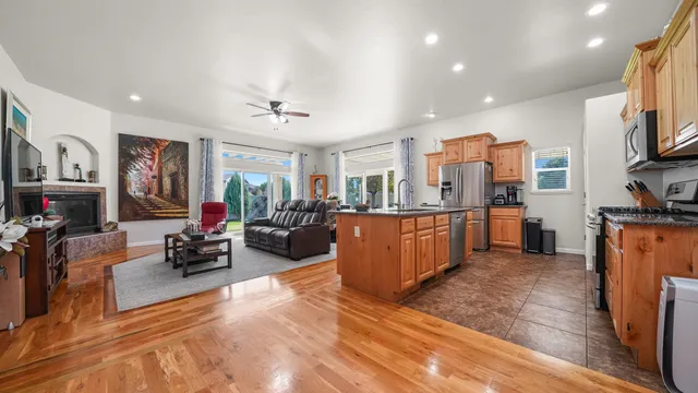 a living room with furniture kitchen area and a flat screen tv