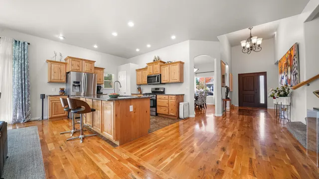 a living room with stainless steel appliances lots of furniture and kitchen view