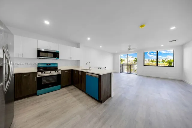 a kitchen with stainless steel appliances granite countertop a refrigerator a stove top oven a sink and dishwasher with wooden floor