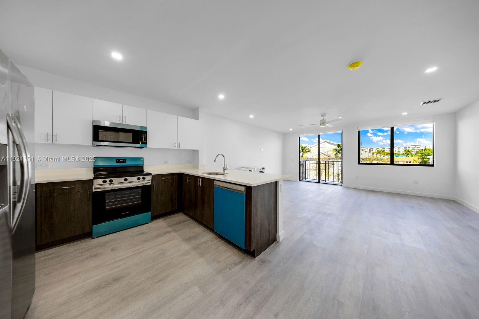 20 Northeast 19th Avenue, Unit 210 Pompano Beach, FL 33060 - Photo 3 of 18 a kitchen with stainless steel appliances granite countertop a refrigerator a stove top oven a sink and dishwasher with wooden floor