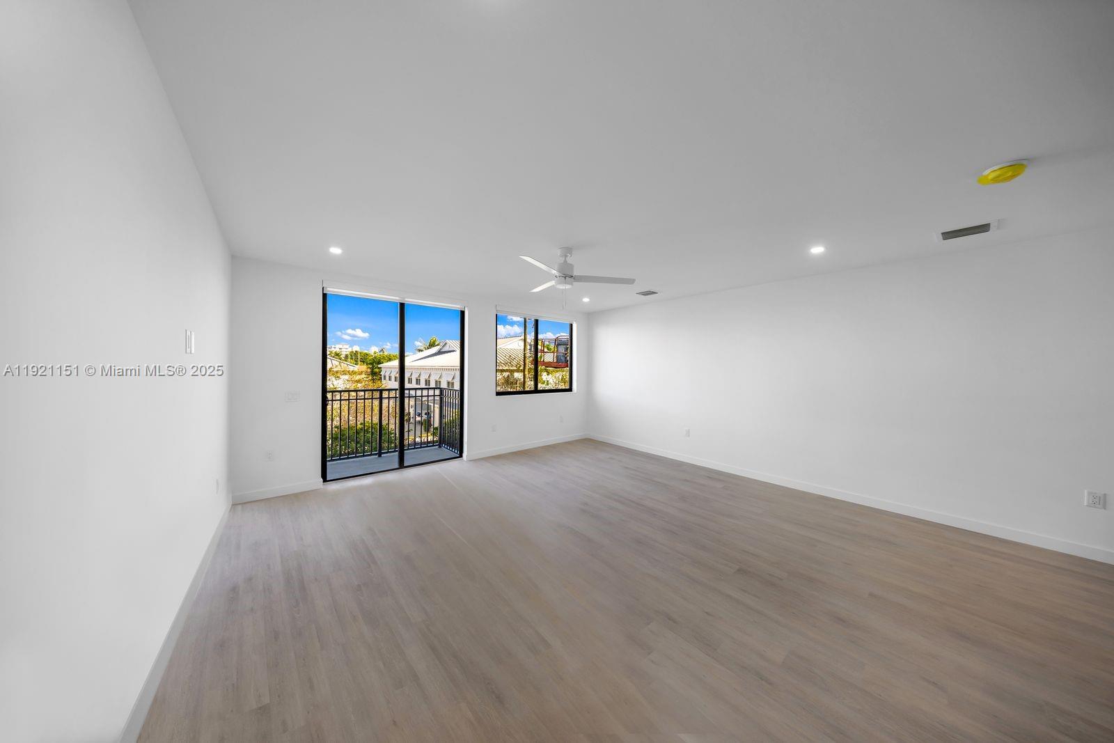 20 Northeast 19th Avenue, Unit 210 Pompano Beach, FL 33060 - Photo 8 of 18 a view of an empty room with a window and wooden floor