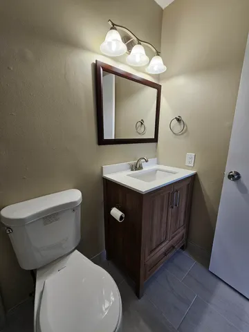 a bathroom with a toilet sink and mirror