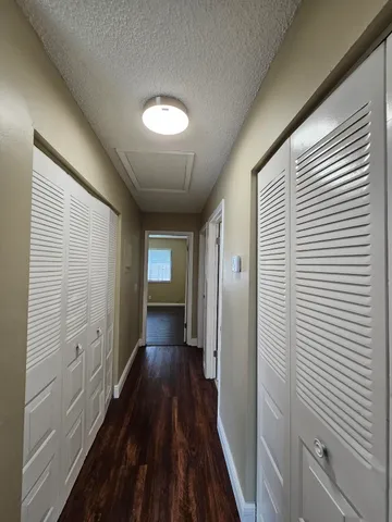 a view of a hallway with wooden floor and staircase