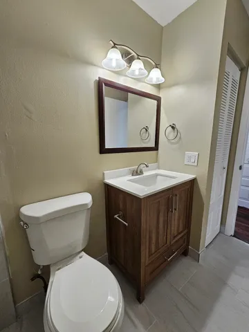 a bathroom with a toilet sink and mirror