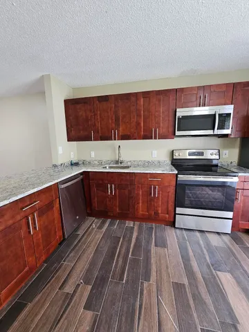 a kitchen with wooden floors and wooden cabinets