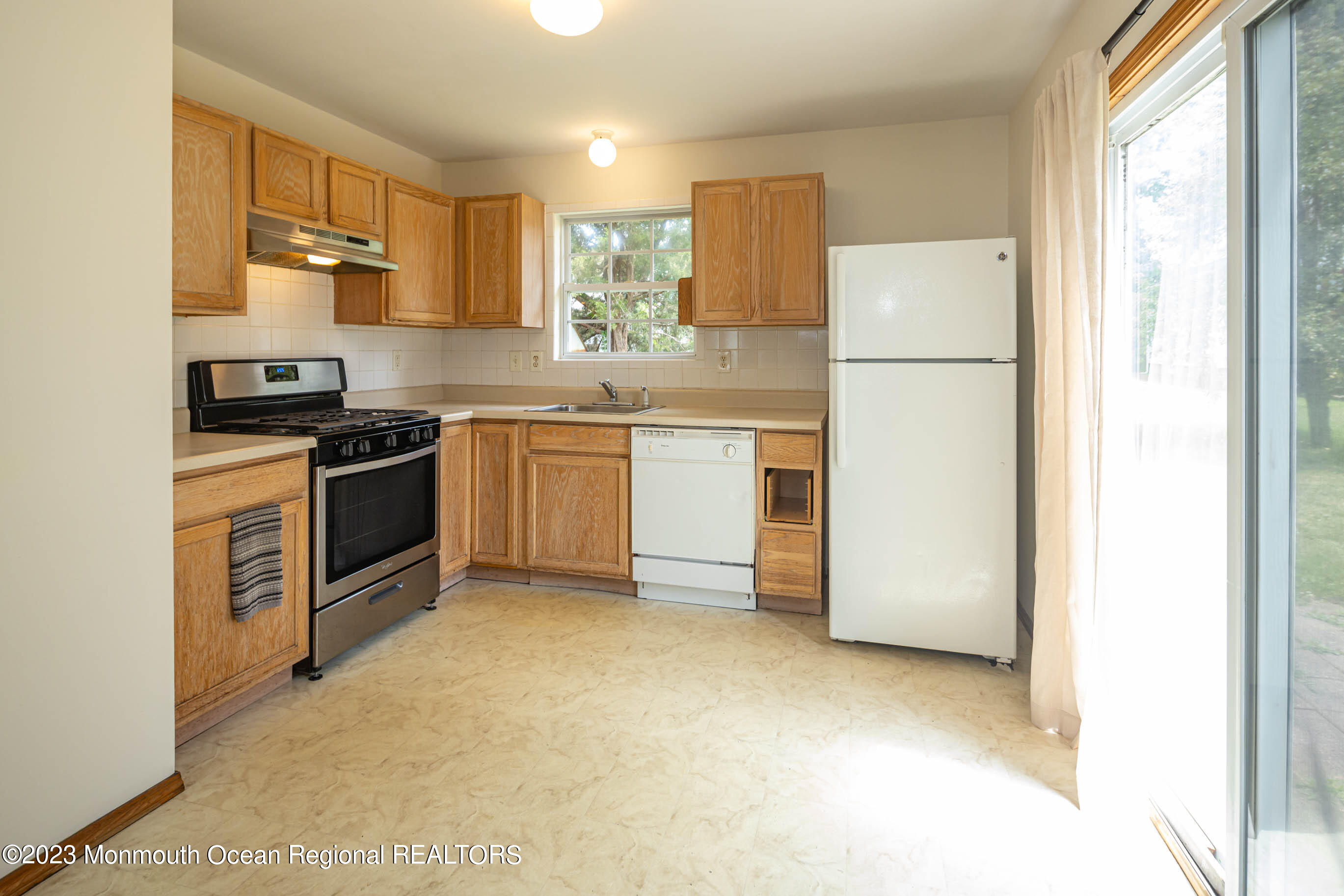 244 Raritan Street Keyport, NJ 07735 - Photo 7 of 20 a kitchen with a refrigerator a stove top oven and cabinets